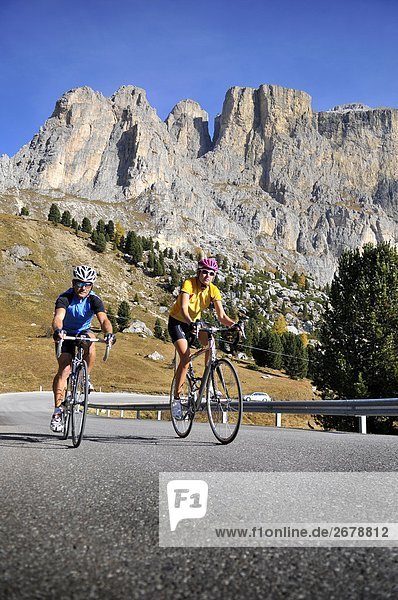 Two mountain bikers cycling together  Dolomites  Italy