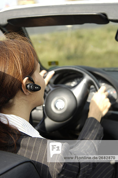 Close-up of woman using bluetooth while driving car