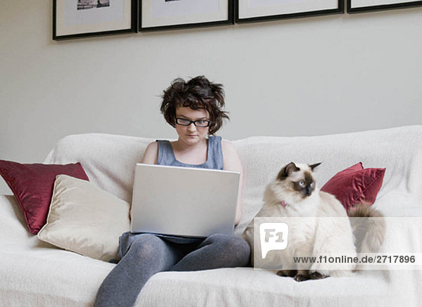 Female holding a cat and a laptop