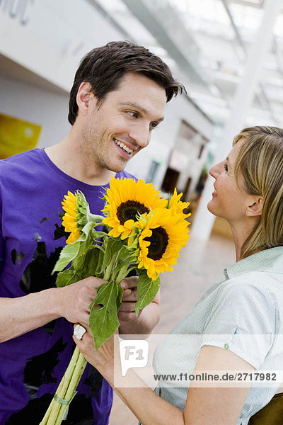 Mann schenkt einer Frau Blumen