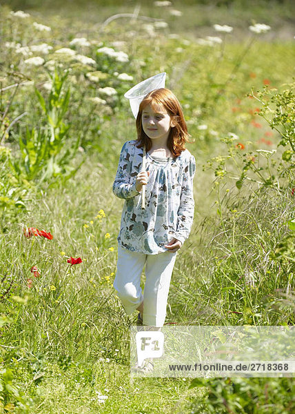 Young girl in field with butterfly net