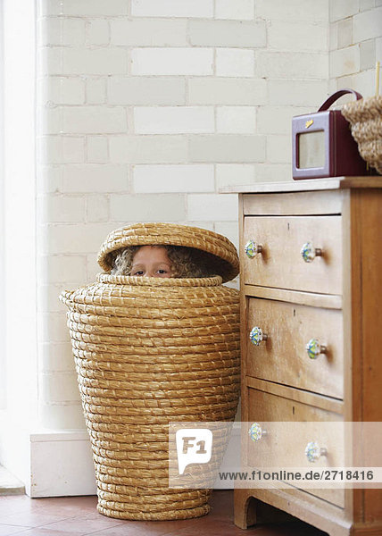 Child hiding in laundry basket