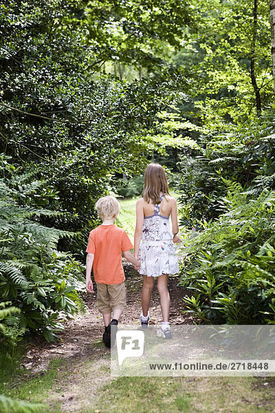 Boy and girl walking through forest