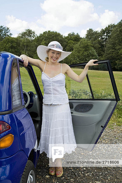 Junge Frau steht beim Elektroauto