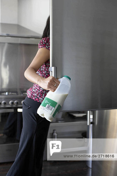Frau bekommt Milch aus dem Kühlschrank