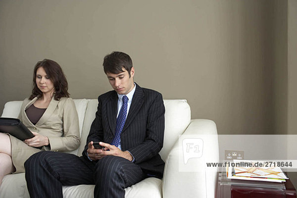 Businessman and woman sitting on sofa