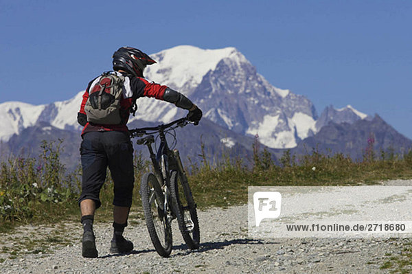 Mountain biker pushing his bike