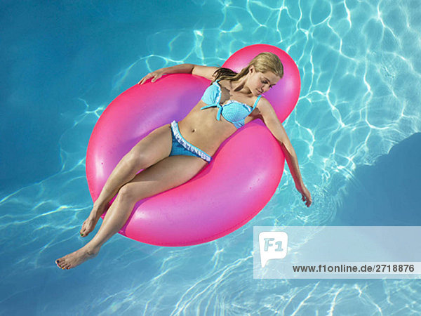 Girl in inflatable chair in pool