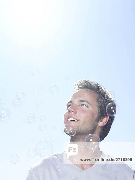 Man in sun looking at bubbles