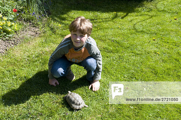 Boy and turtle in garden