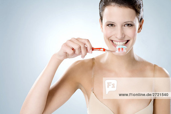 Junge Frau beim Zähneputzen  lächelnd  Nahaufnahme