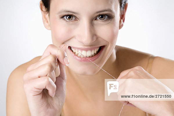 Junge Frau mit Zahnseide  Nahaufnahme