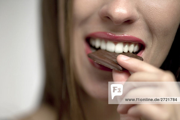 Young woman eating chocolate candy  portrait