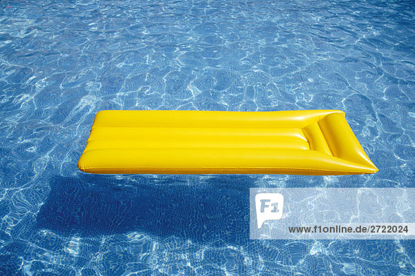 Gelbes Luftbett im Pool schwimmend  erhöhte Ansicht