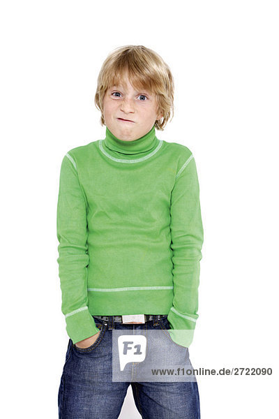 Junge (10-11) stehend mit Händen in den Taschen  Grimassen  Portrait