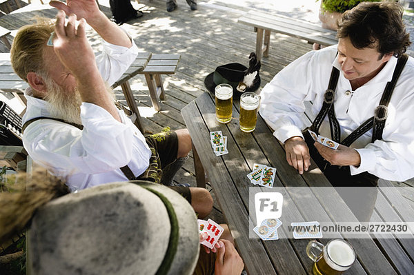Oben,  Männer spielen Karten im Biergarten,  erhöhte Ansicht