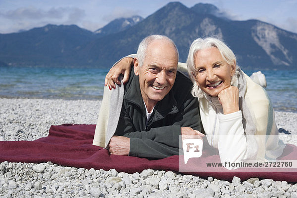Germany  Bavaria  Walchensee  Senior couple relaxing on lakeshore