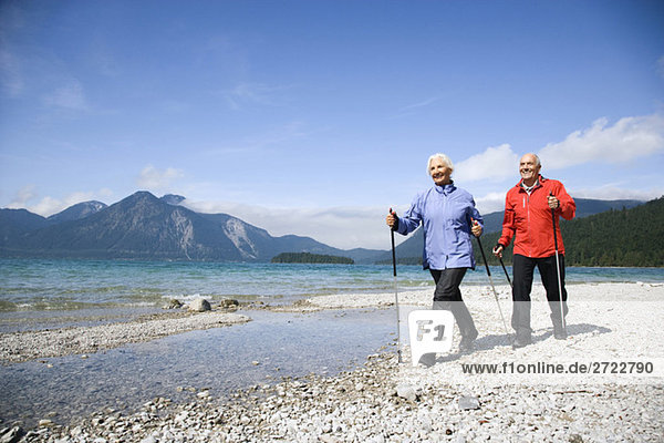 Germany  Bavaria  Walchensee  Senior couple  Nordic Walking on lakeshore