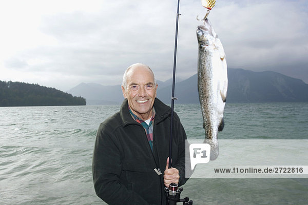 Senior Mann  der im See fischt.