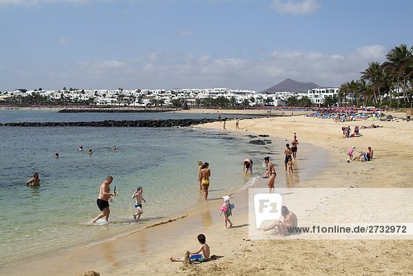 Tourists on beach  Costa Teguise  Playa des Cucharas  Lanzarote  Canary Islands  Spain