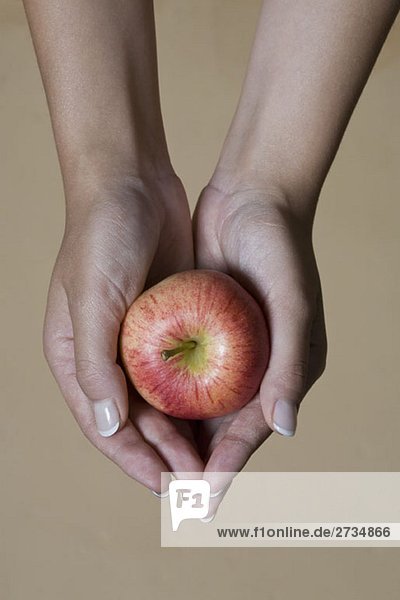 A woman's hands holding an apple