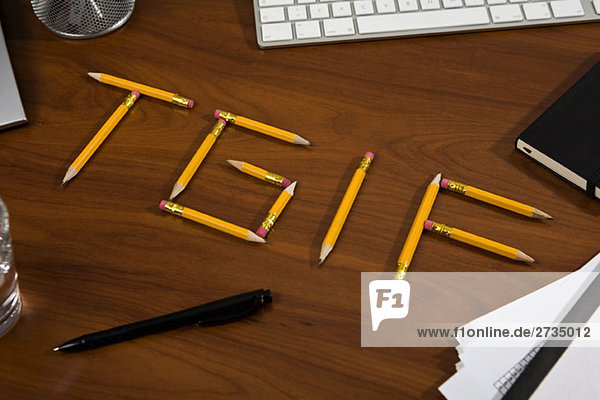 Bleistifte auf einem Schreibtisch angeordnet  um TGIF zu buchstabieren.