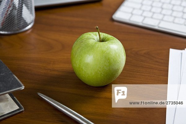 Ein grüner Apfel auf einem Bürotisch