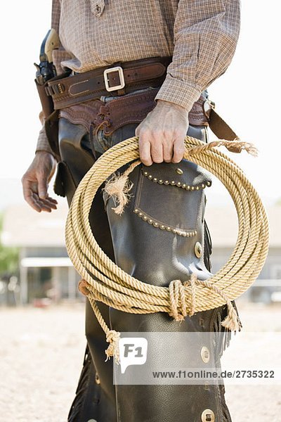 Ein Cowboy hält ein Seil.