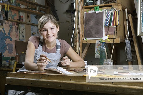 Eine junge Frau  die in einem Kunstatelier arbeitet  Porträt