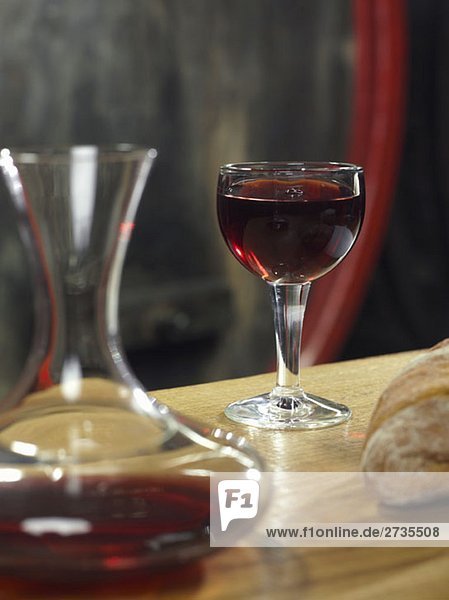 Ein Glas Rotwein  eine Karaffe Rotwein und ein Brot  Stilleben