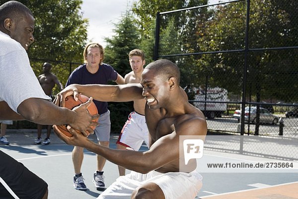 Zwei Basketballspieler kämpfen um einen Basketball.