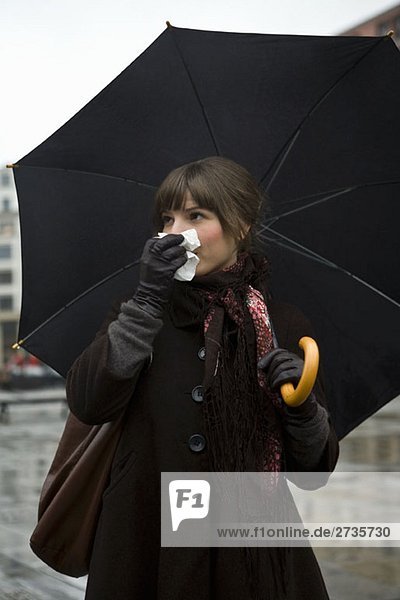 Junge Frau mit Gewebe und Regenschirm