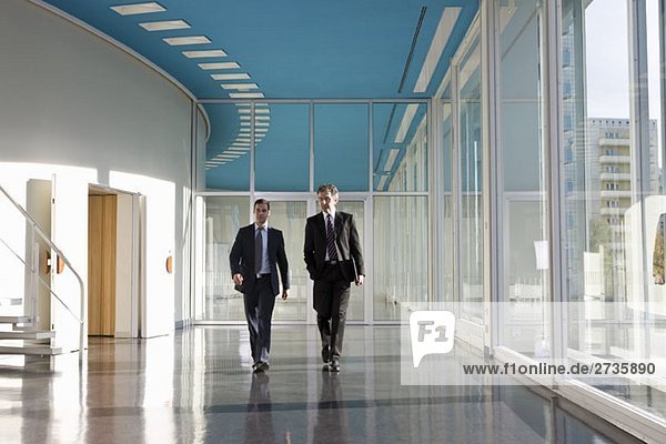 Two businessmen walking in the foyer of a convention center