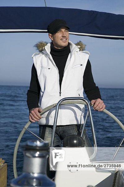 Ein Mann am Ruder einer Yacht