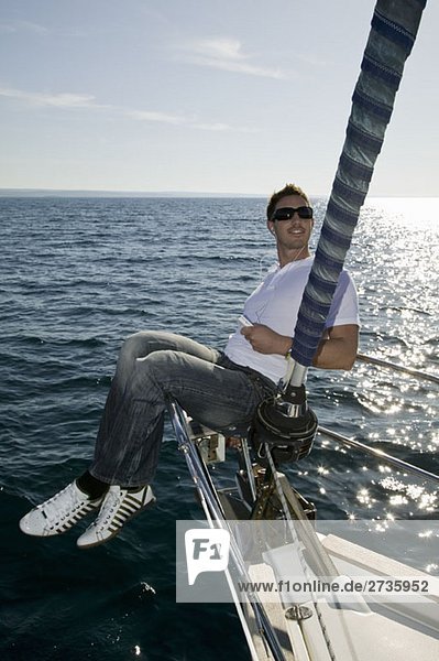 A man sitting on the bow of a yacht