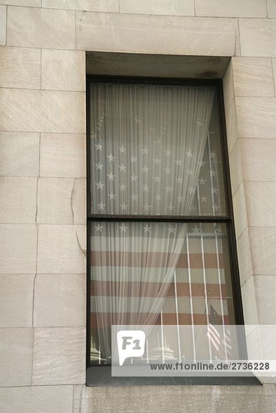 Die amerikanische Flagge spiegelt sich in einem Fenster.