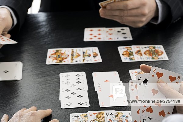 Close-up of two people playing cards