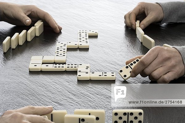 Close-up of two people playing dominos