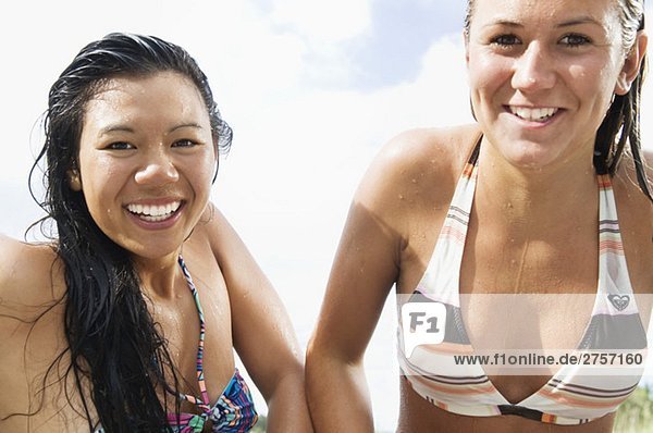 Two smiling girls in bikinis