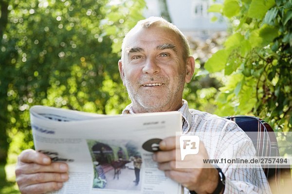 Man reading the newspaper in the garden