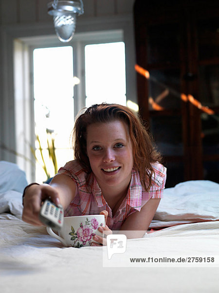 A young Scandinavian woman drinking tea in the bed Sweden.