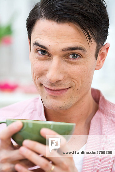 Ein Mann  hält ein eine Tasse Tee Schweden.