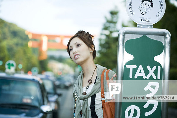 Junge Frau wartet am Taxistand