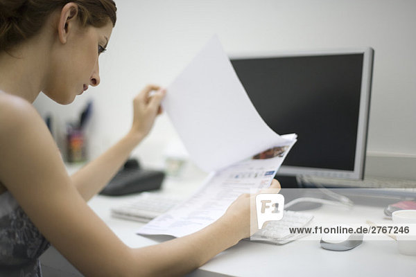 Woman reviewing document at desk