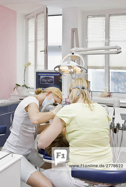 Zahnarzt mit Patient und Assistentin