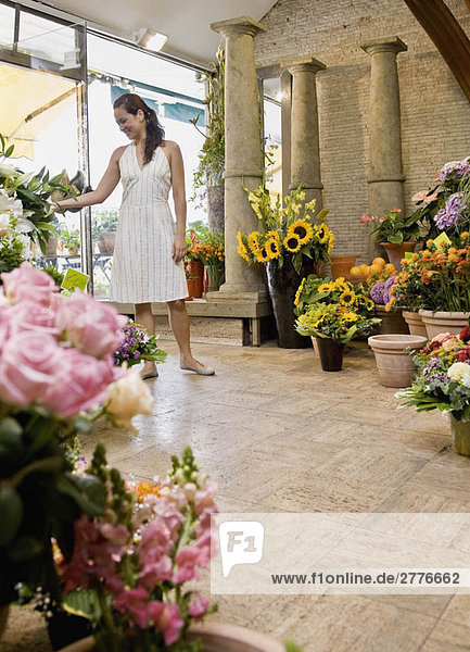 Frau steht in einem Blumenladen