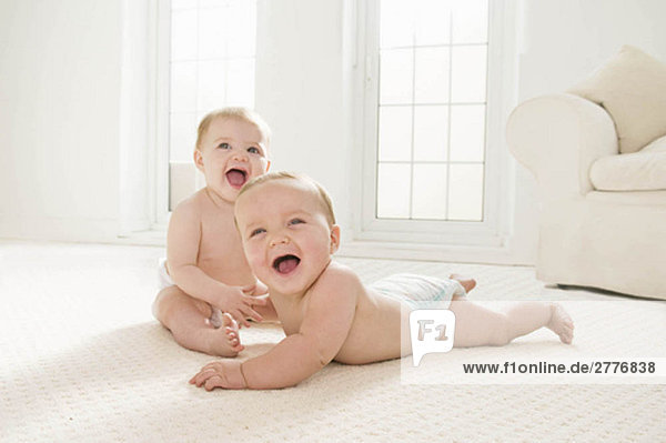 Zwei Babys  die zusammen lachen.