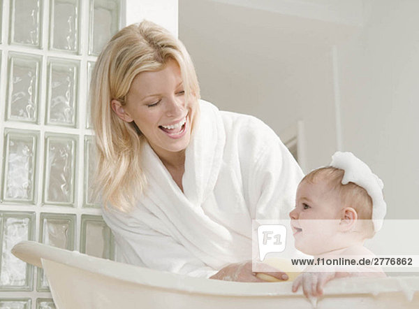 A mum bathing her baby girl.
