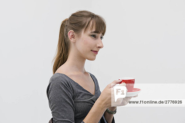 Eine Frau hält eine rote Tasse.