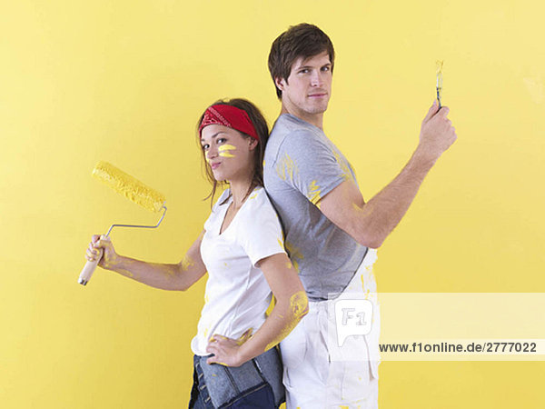 Couple posing in front of wall.